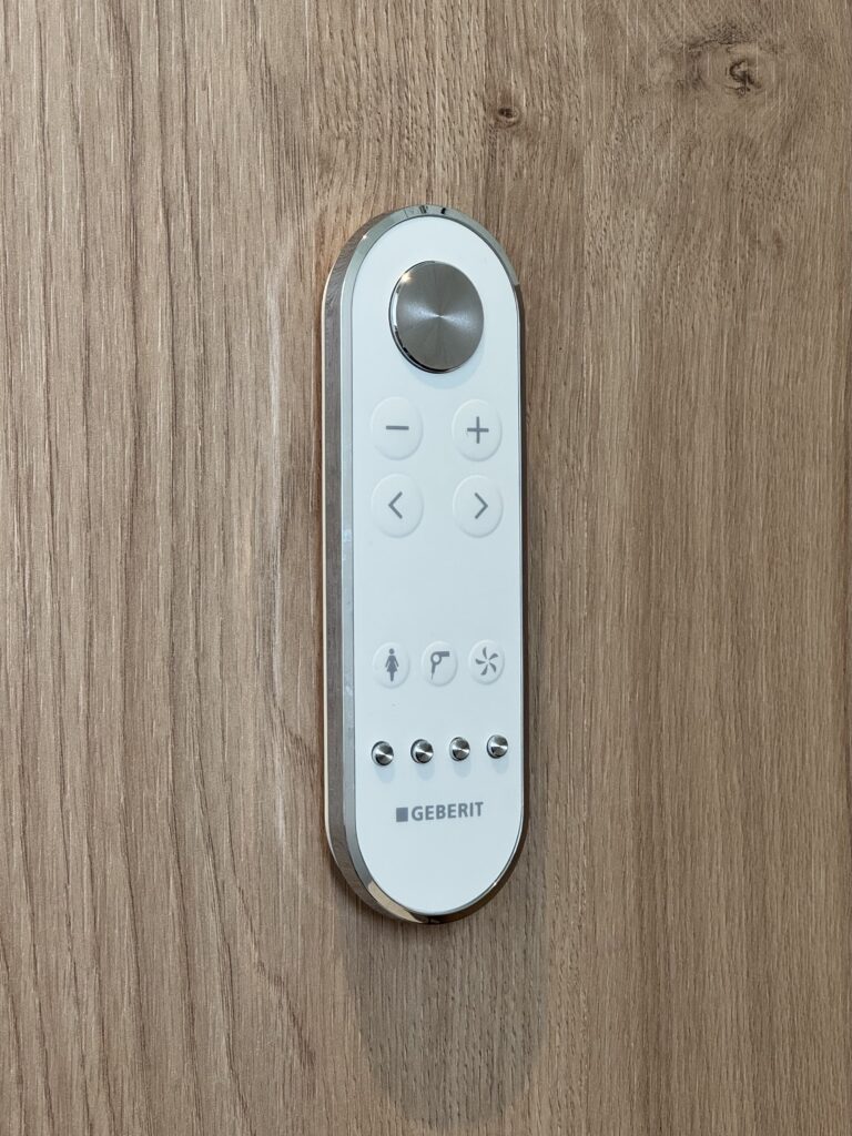 Intuitive Geberit Fernbedienung für Geberit Dusch-WC mit Wandhalterung in minimalistischem Design